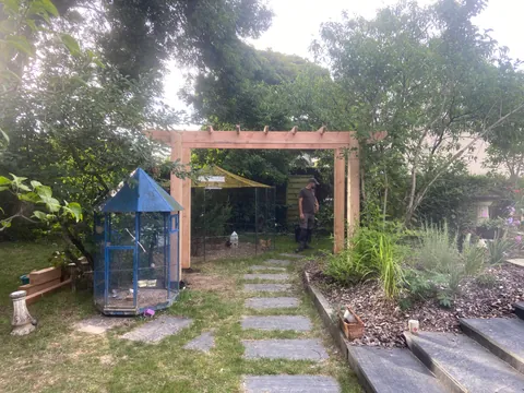 Pergola en bois et allee en pas japonais dans un jardin paysager a Angers